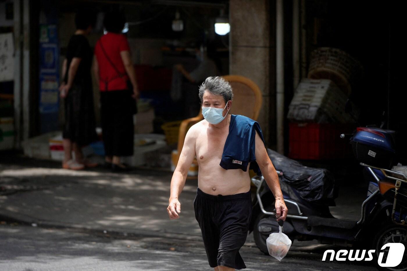 본문 이미지 - 20일(현지시간) 중국 상하이에 무더위가 한창인 가운데 거리에서 상의를 탈의한 남성이 식사를 포장해 가고 있다. 2022.07.20 ⓒ 로이터=뉴스1 ⓒ News1 유민주 기자