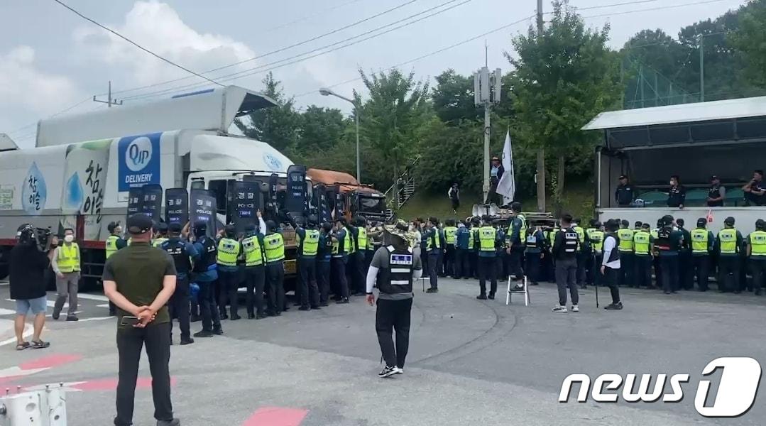 본문 이미지 - 23일 하이트진로 청주공장 앞에서 경찰 기동대가 화물연대 화물차를 이동해 공장 진출입로를 확보하고 있다. ⓒ 뉴스1