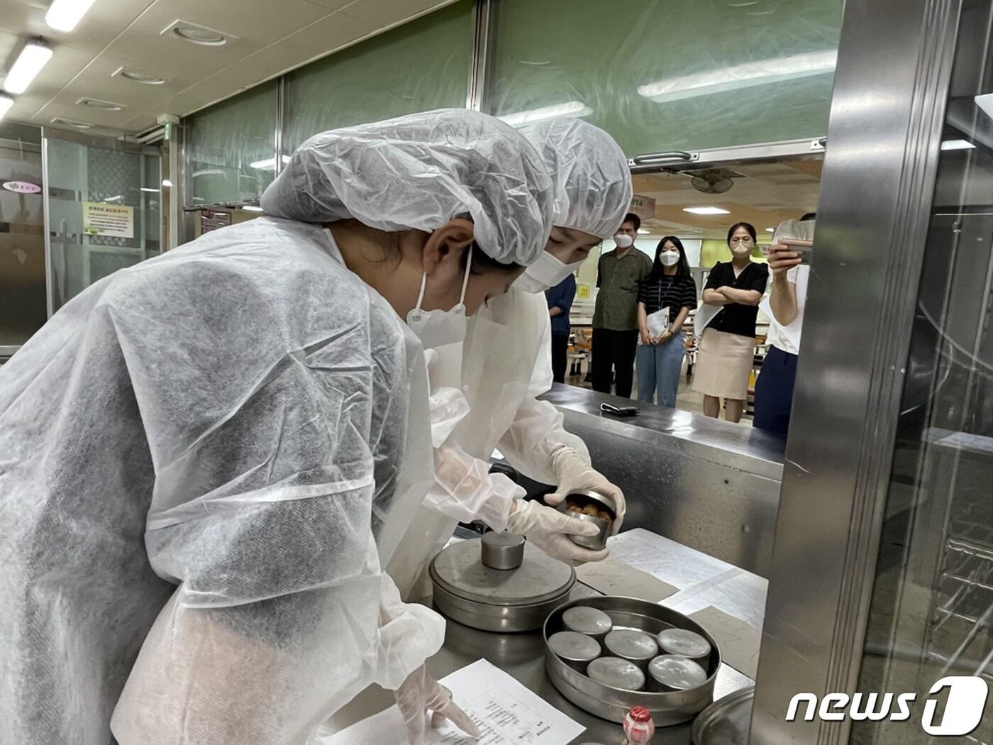 본문 이미지 - 성남시가 지난 14일 판교중학교에서 진행한 ‘식중독 발생 현장 대응 모의훈련’ 때 참가자들이 보존식을 확인하고 있는 모습.(성남시 제공) ⓒ News1 