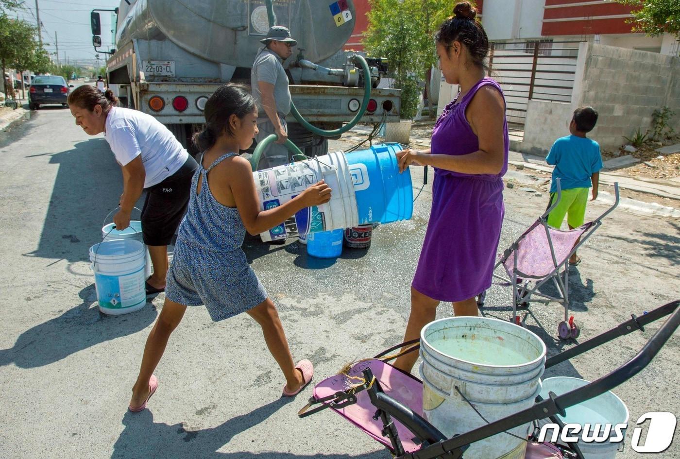 본문 이미지 - 몇년째 가뭄에 시달리고 있는 멕시코 북부 몬테레이의 한 마을 주민들이 5일(현지시간) 물탱크 트럭에서 물을 받고 있다. 2022.07.05 ⓒ AFP=뉴스1 ⓒ News1 정윤미 기자