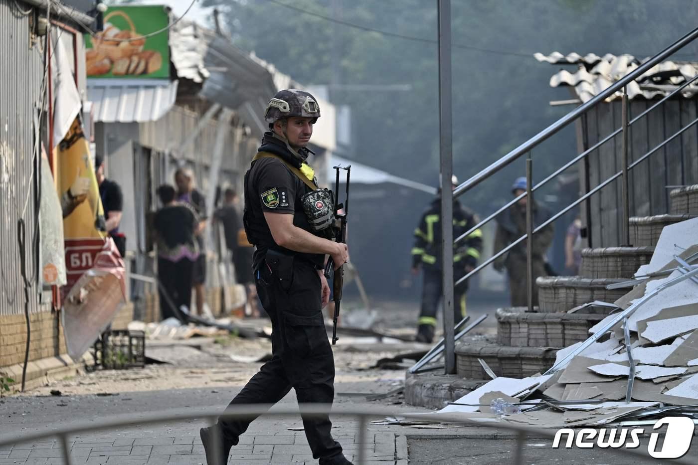 본문 이미지 - 3일(현지시간) 우크라이나 도네츠크의 슬로비안스크에서 러시아 군의 로켓 공격을 받아 파괴된 상점 앞을 경찰이 순찰하고 있다. ⓒ AFP=뉴스1 ⓒ News1 우동명 기자