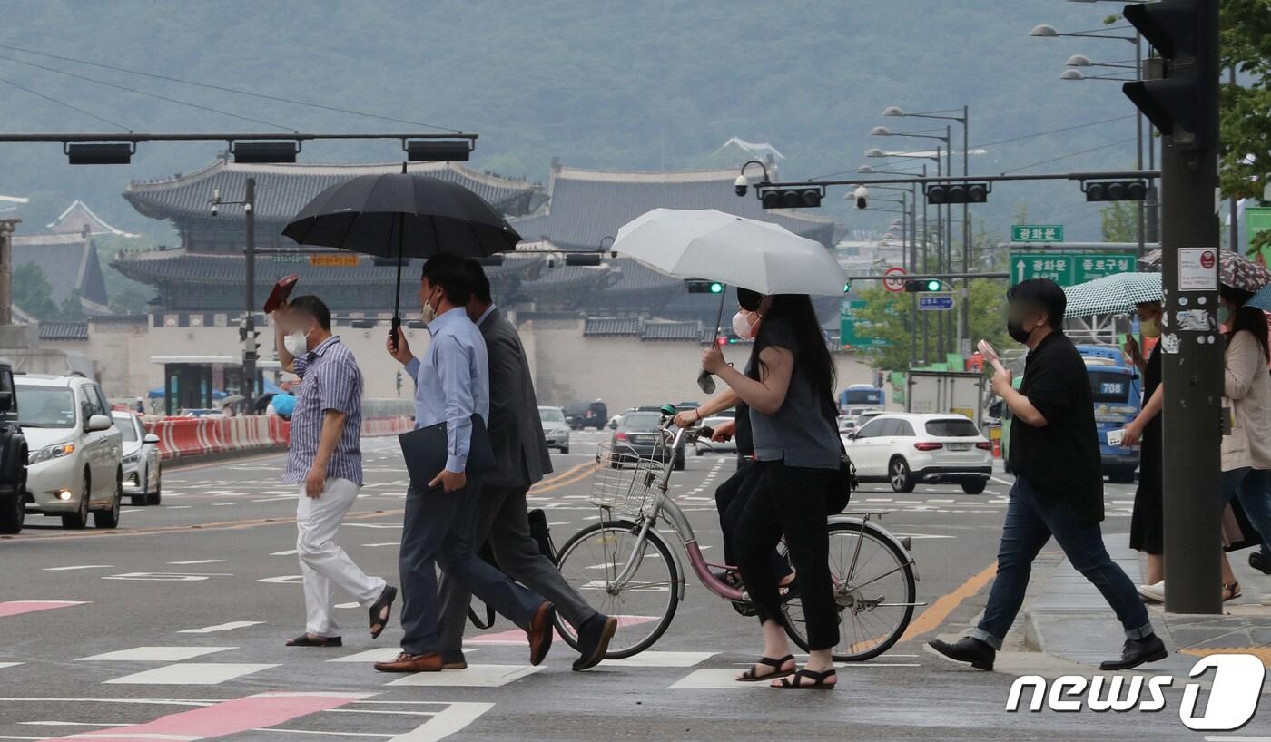 서울 도심에 소나기가 내린 이달 4일 서울 세종대로사거리 횡단보도에서 우산을 미처 준비못한 시민이 가방으로 비를 피하며 발걸음을 재촉하고 있다(뉴스1DB)ⓒ News1 박세연 기자