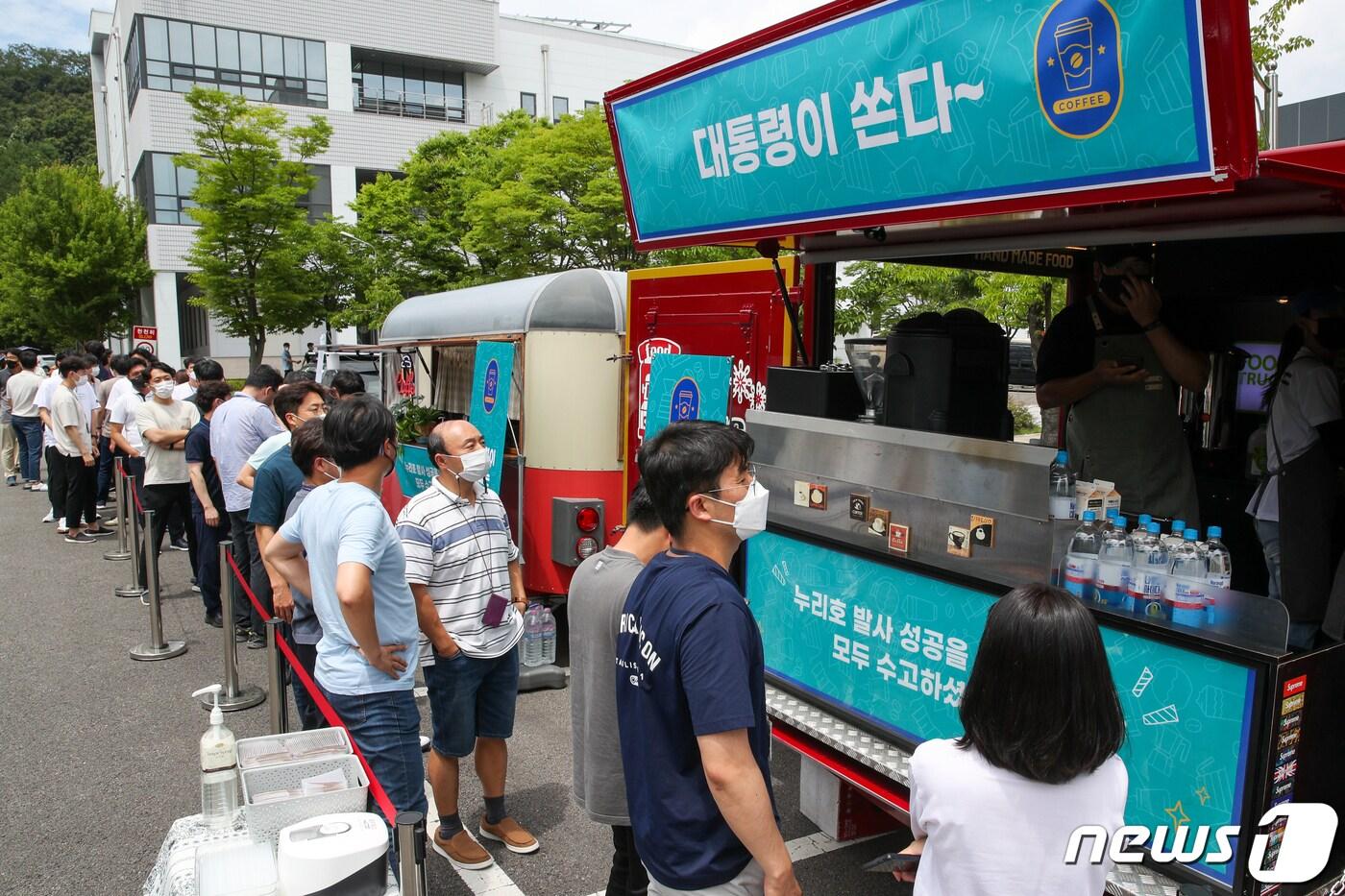 본문 이미지 - 한국항공우주연구원 직원들이 6일 대전 유성구 항우연에서 음료를 주문하기 위해 줄 서 있다. 윤석열 대통령은 이날 누리호 2차 발사 성공 등을 위해 노력한 연구원들을 위해 커피와 쿠키 푸드트럭을 보냈다. 대통령실사진기자단 2022.7.6/뉴스1 ⓒ News1 안은나 기자