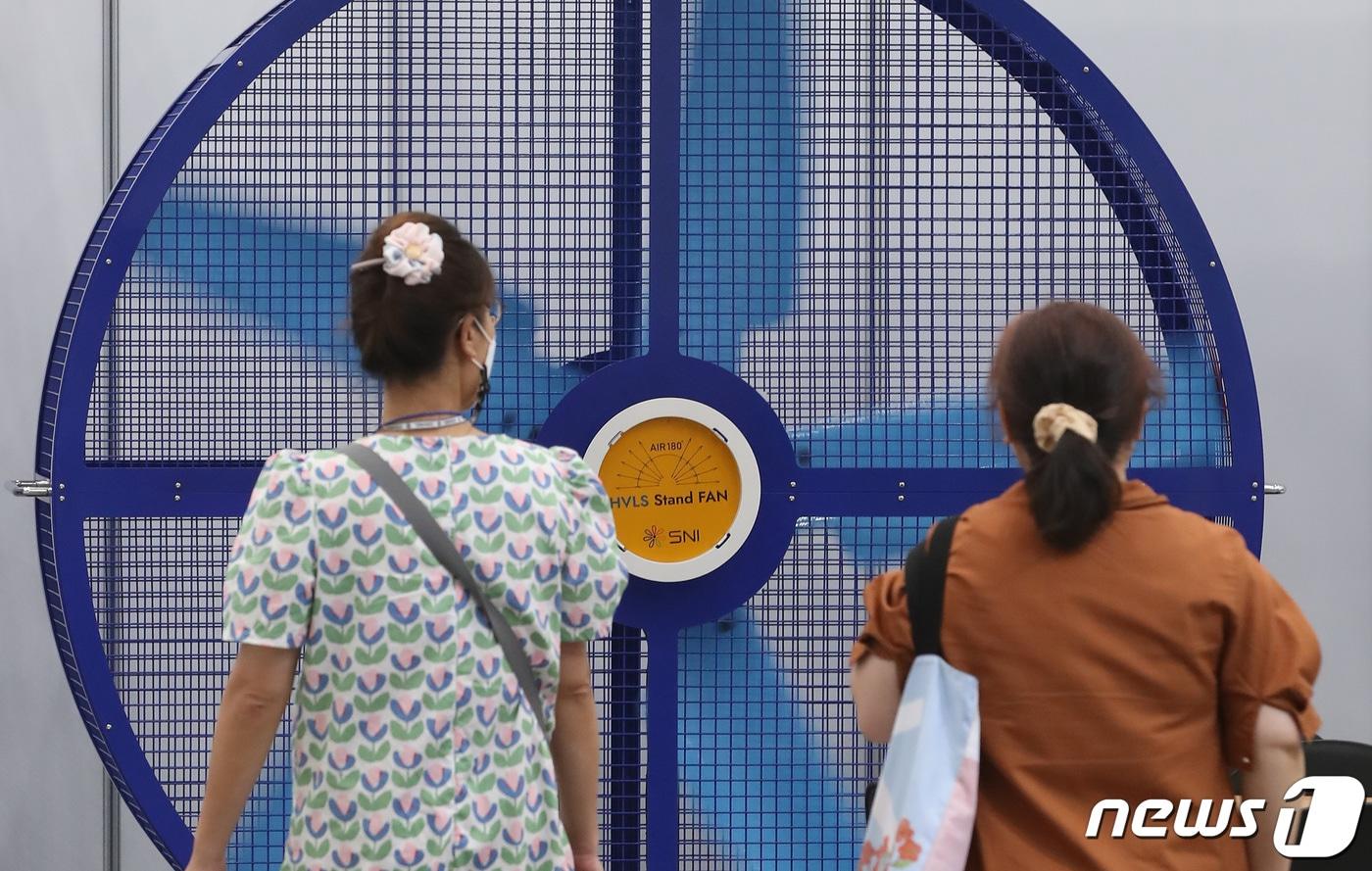 본문 이미지 - 6일 대구 엑스코(EXCO)에서 개막한 '대한민국 국제 쿨산업전'을 찾은 시민들이 에너지 절약에 효과가 있는 사계절용 고효율 팬을 살펴보고 있다. 2022.7.6/뉴스1 ⓒ News1 공정식 기자