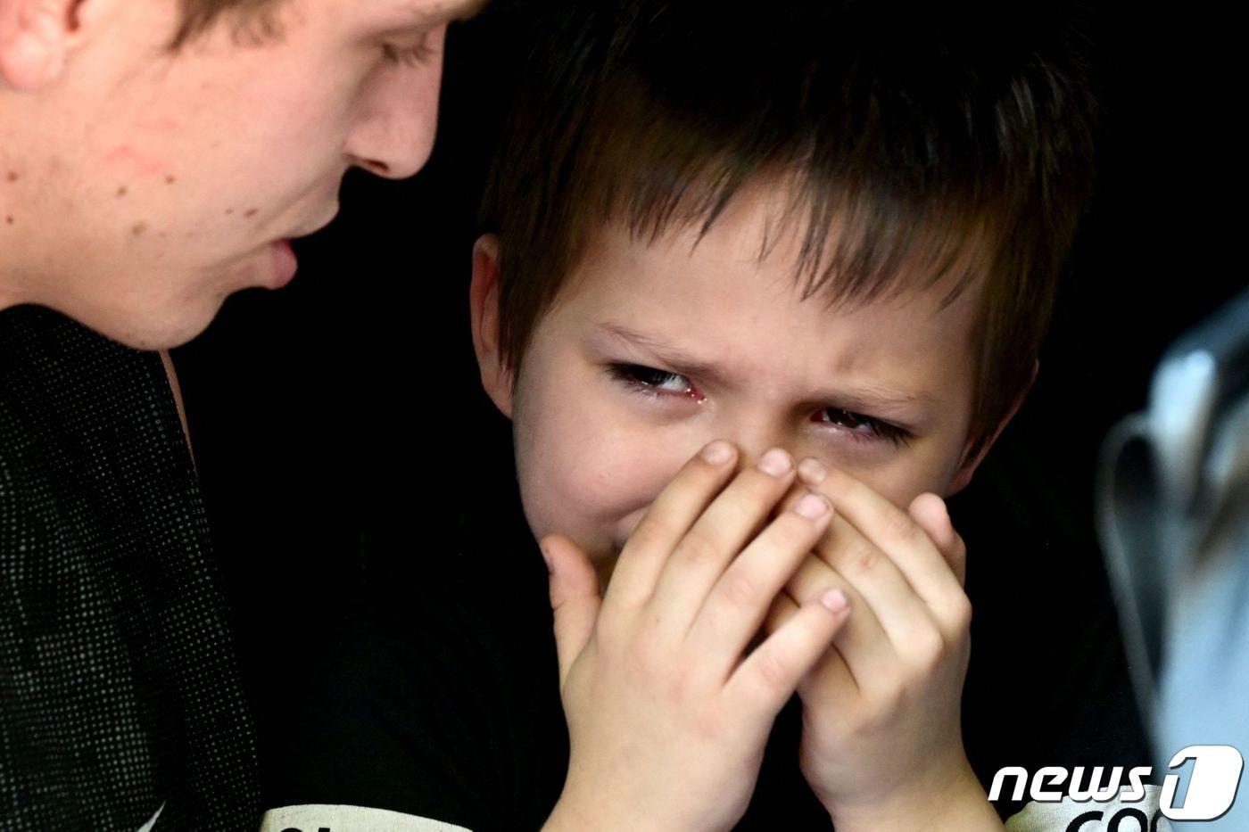 러시아의 침공 속 우크라이나 슬로비안스크에서 주민이 드니프로로 피난을 하기 위해 버스를 기다리며 우는 아들을 달래고 있다. ⓒ AFP=뉴스1 ⓒ News1 우동명 기자