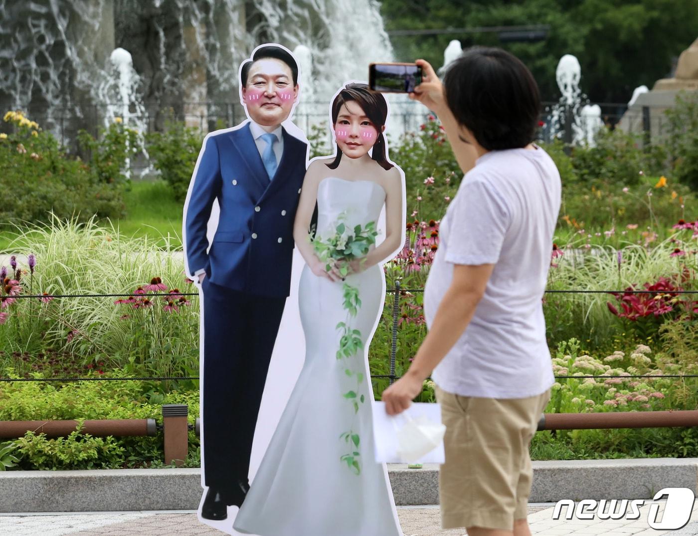 본문 이미지 - 7일 오후 서울 종로구 청와대 분수대 앞에 설치된 윤석열 대통령과 김건희 여사의 등신대 앞에서 한 시민이 사진을 찍고 있다.  ⓒ News1