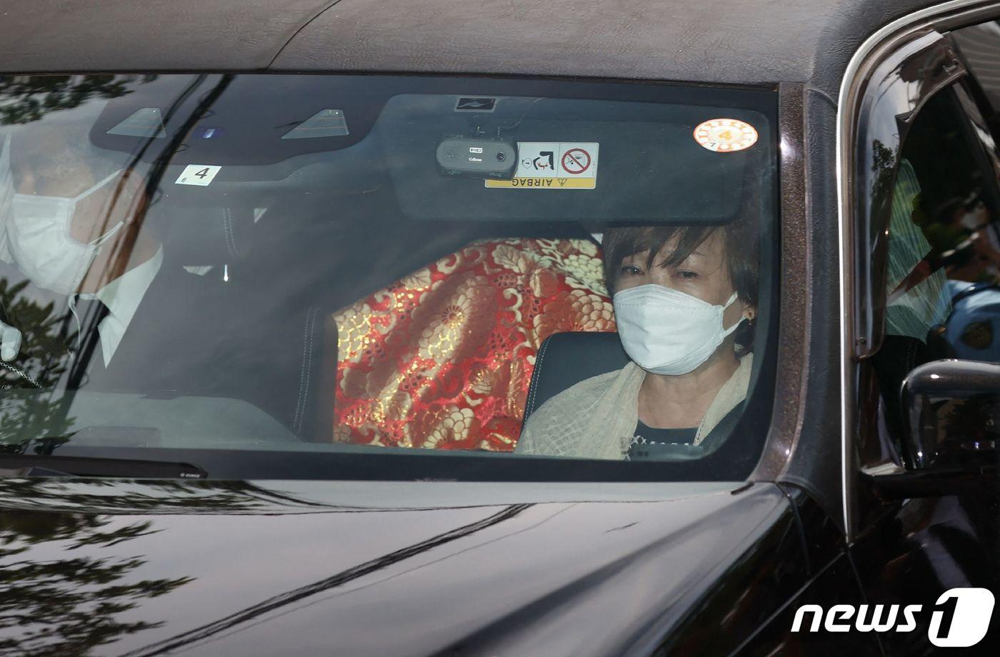 본문 이미지 - 아베 신조 전 일본 총리가 선거 유세중 총에 맞고 숨진 다음날인 9일 아베 전 총리의 부인 아베 아키 여사가 운구차에 탑승해 자택으로 들어서고 있다. ⓒ AFP=뉴스1 ⓒ News1 이성철 기자