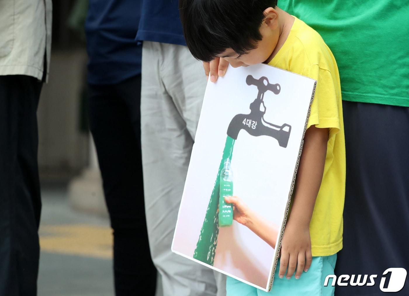 본문 이미지 - 한 어린이가 수도꼭지에서 녹색 물이 흘러나오는 그림을 물끄러미 바라보고 있다. 2022.8.1/뉴스1 ⓒ News1 공정식 기자