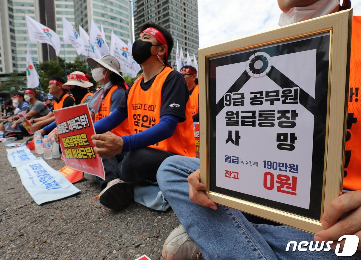 본문 이미지 - 전국공무원노동조합(이하 전공노) 회원들이 10일 오후 서울 용산구 대통령실 인근에서 가진 '임금인상 쟁취 및 인력감축 저지 총력투쟁 결의대회'에서 '9급 공무원 월급통장 사망' 문구를 들고 있다. 2022.8.10/뉴스1 ⓒ News1 송원영 기자