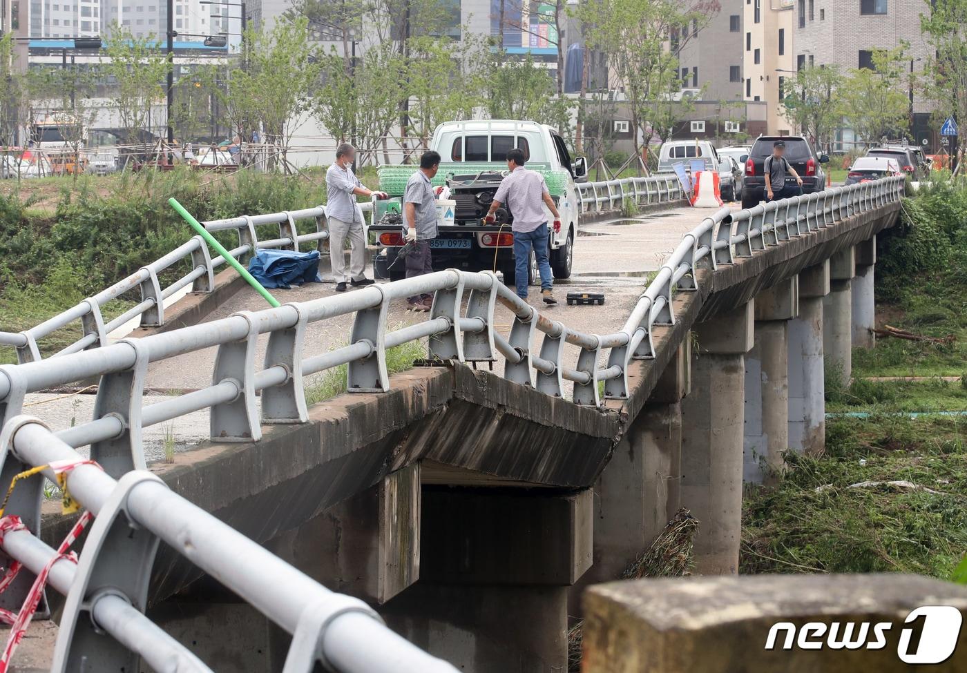 11일 경기도 고양시 창릉천의 한 다리가 집중호우로 교각이 내려 앉아 상판이 붕괴돼 관계자들이 출입통제 작업을 하고 있다. 2022.8.11/뉴스1 ⓒ News1 송원영 기자
