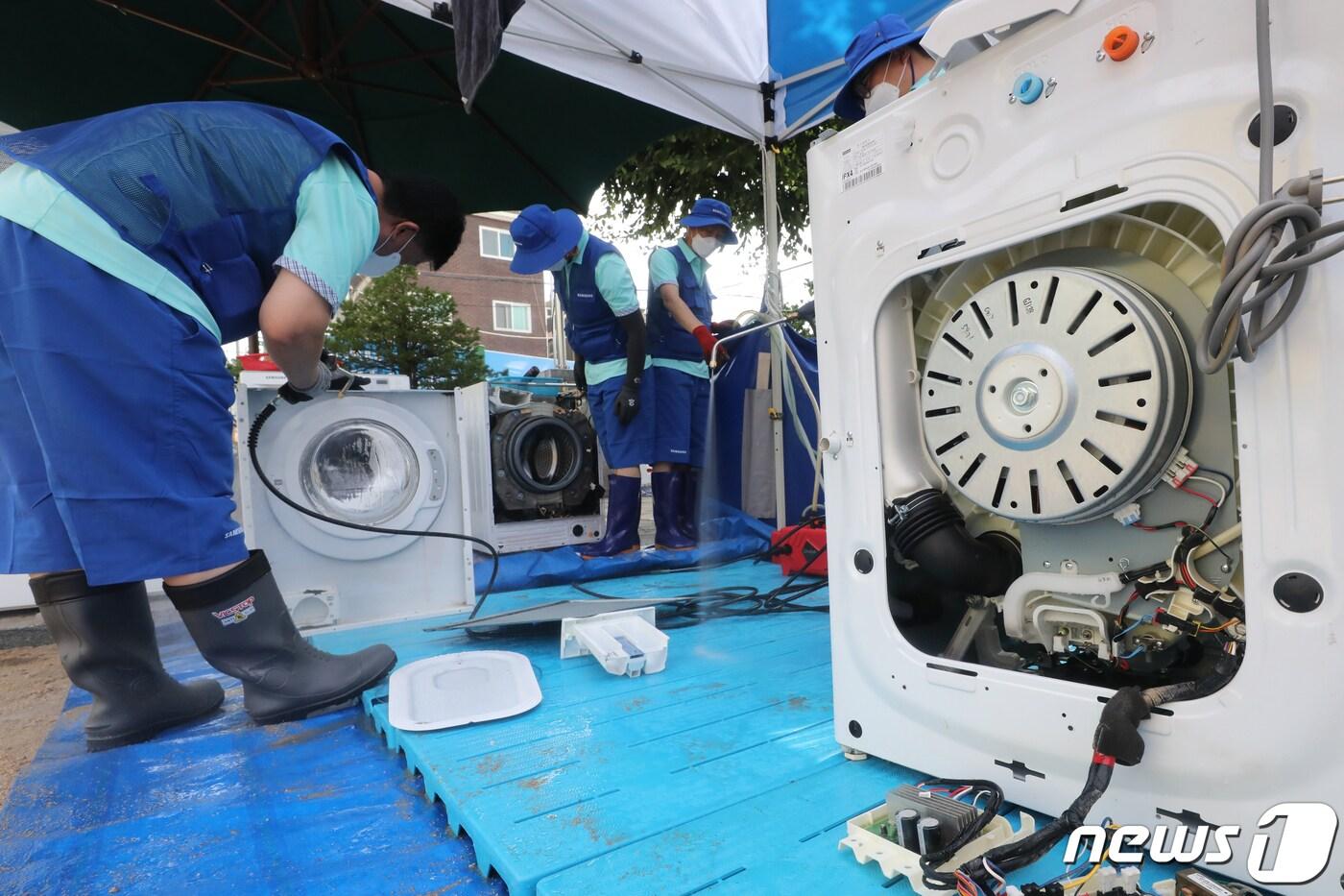 삼성전자 서비스센터 직원들이 11일 오후 서울 관악구 남부초등학교에 마련된 '침수피해주민 가전제품 무료수리 서비스 부스'에서 가전제품을 수리하고 있다. 무상수리팀에는 삼성전자, LG전자, 위니아·위니아에이드 가전 3사가 참여한다. 2022.8.11/뉴스1 ⓒ News1 황기선 기자