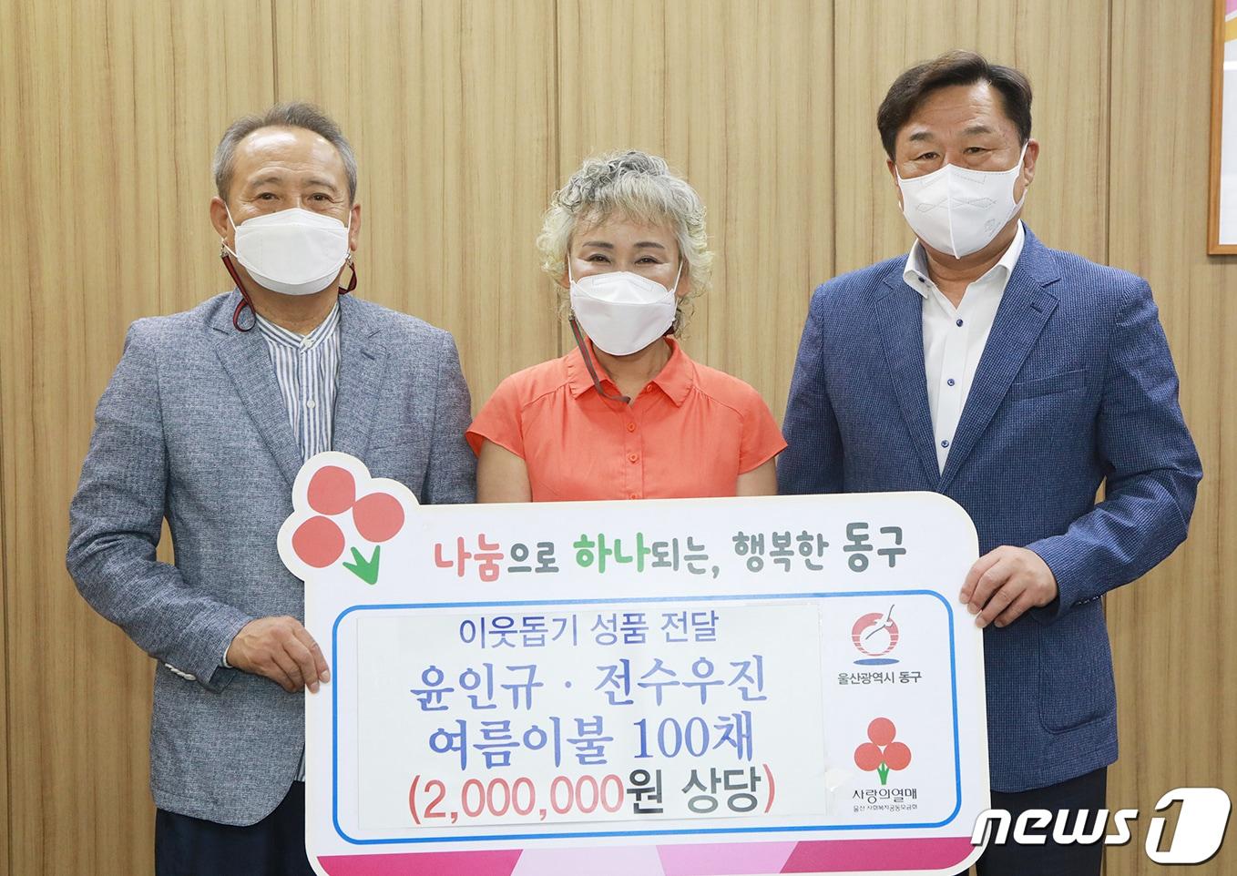 본문 이미지 - 윤인규(왼쪽)·전수우진 부부가 11일 오전 울산 동구청을 찾아 김종훈 동구청장에게 200만원 상당의 여름이불 100개를 전달하고 있다. (울산 동구 제공) ⓒ 뉴스1