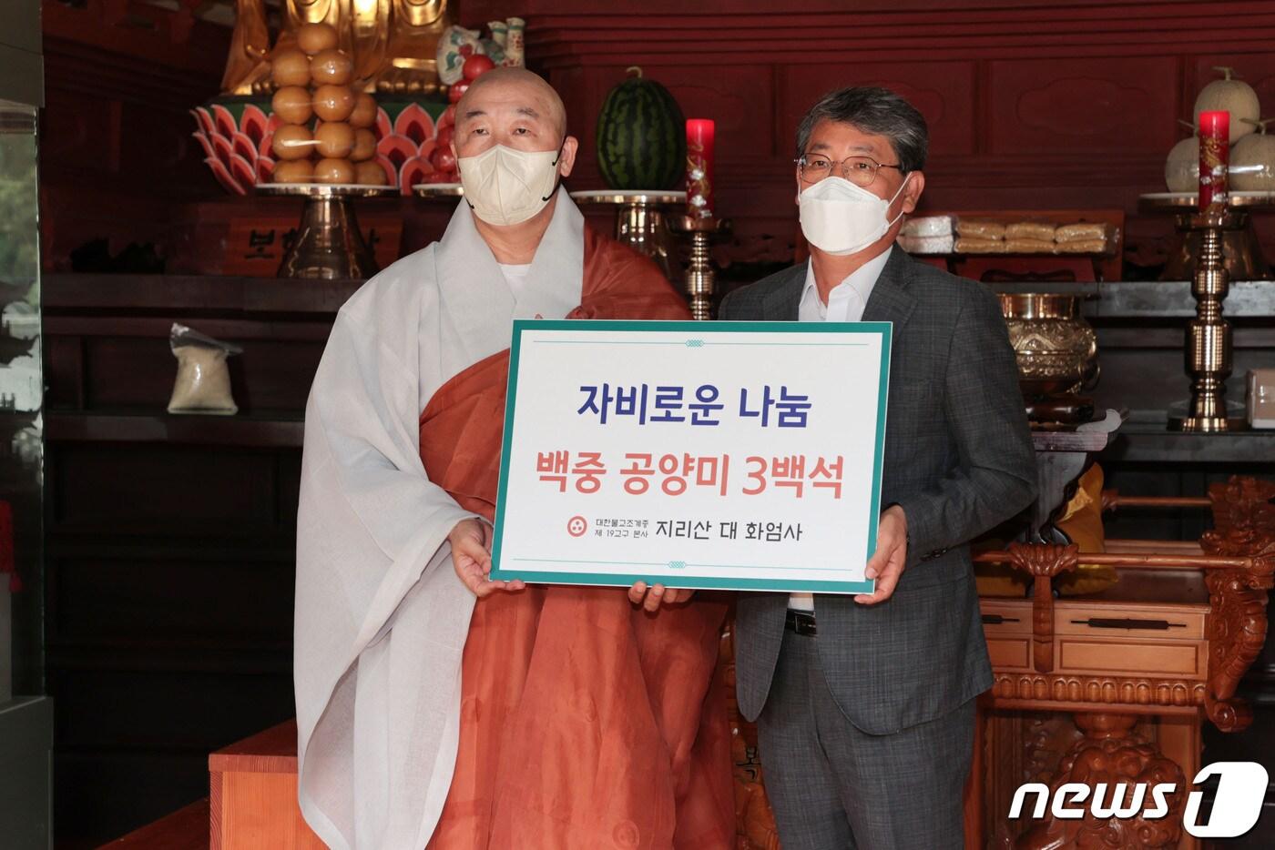 본문 이미지 - 12일  화엄사 주지 덕문스님이 김순호 구례군수에게 백미 300포를 기탁하고 있다(구례군 제공)2022.8.12/@