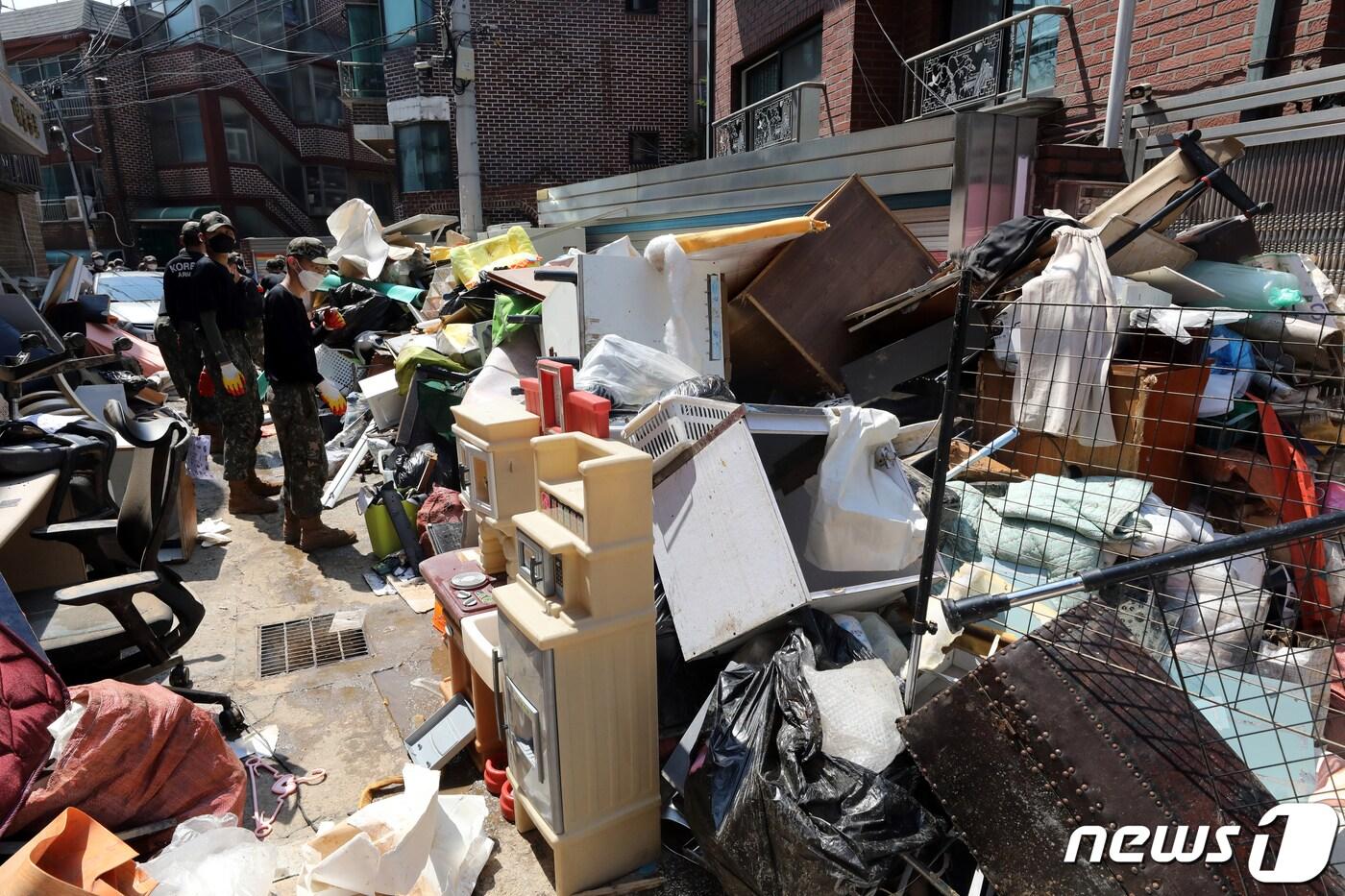 본문 이미지 - 비가 그치고 무더위가 기승을 부린 12일 오후 서울 동작구 성대전통시장에서 육군 52사단 기동대대 장병들이 수해 복구작업을 하고 있다. 2022.8.12/뉴스1 ⓒ News1 황기선 기자