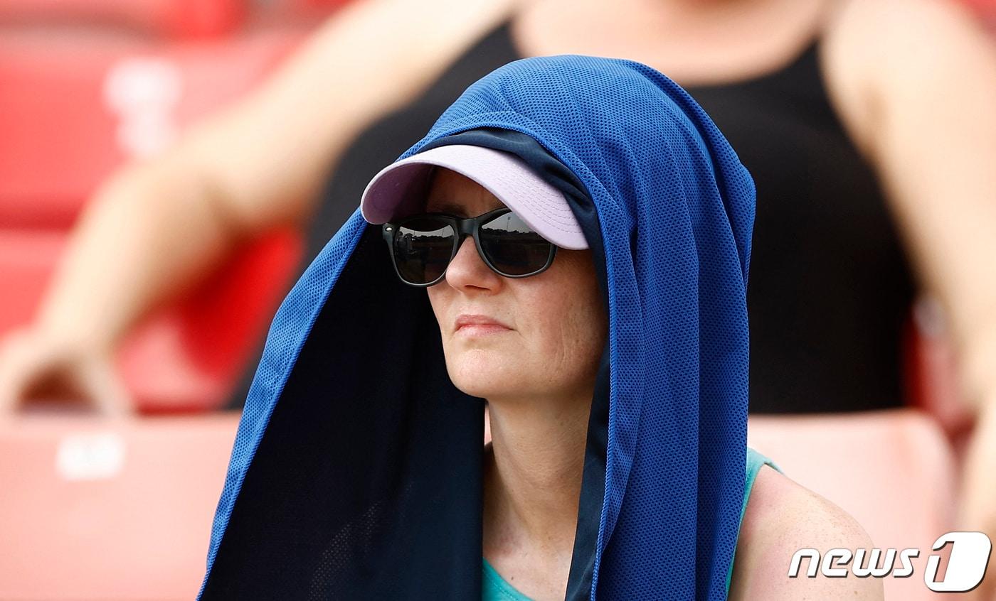 본문 이미지 - 영국 잉글랜드 중부 레스터에서 한 여성이 더위를 피하기 위해 모자와 수건으로 얼굴을 가리고 크리켓 경기를 관람하고 있다. 2022.07.18 ⓒ 로이터=뉴스1 ⓒ News1 정윤미 기자