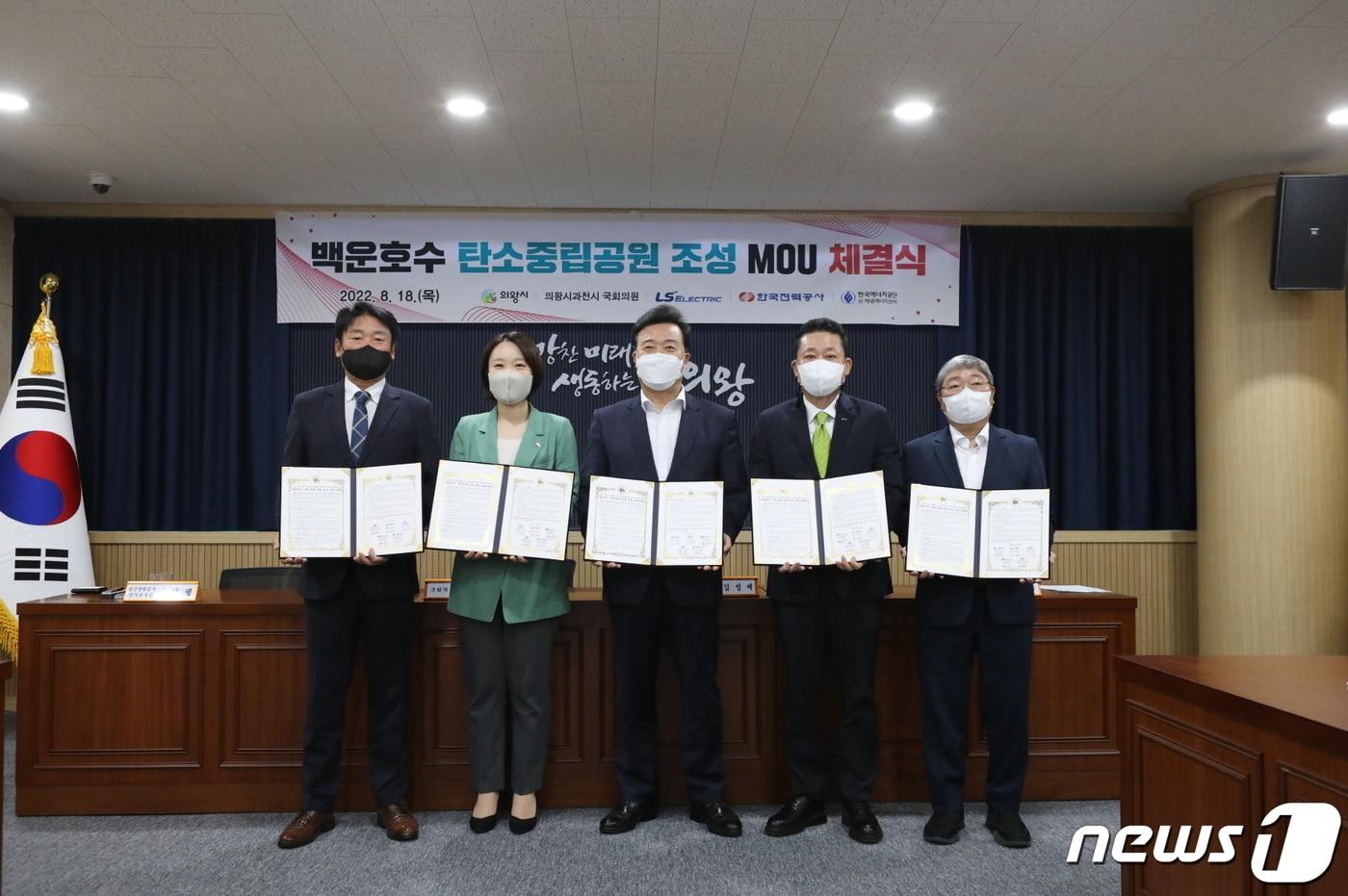 LS일렉트릭은 18일 의왕시청에서 의왕시 등 관계 기관과 함께 의왕 백운호수 탄소중립 공원 조성을 위한 업무협약(MOU)을 체결했다고 밝혔다. 사진은 김성제 의왕시장(오른쪽 세번째), 김종우 LS일렉트릭 사장(오른쪽 두번째), 이소영 국회의원(왼쪽 두번째) 등 관계자들이 업무협약을 체결하고 기념촬영하는 모습