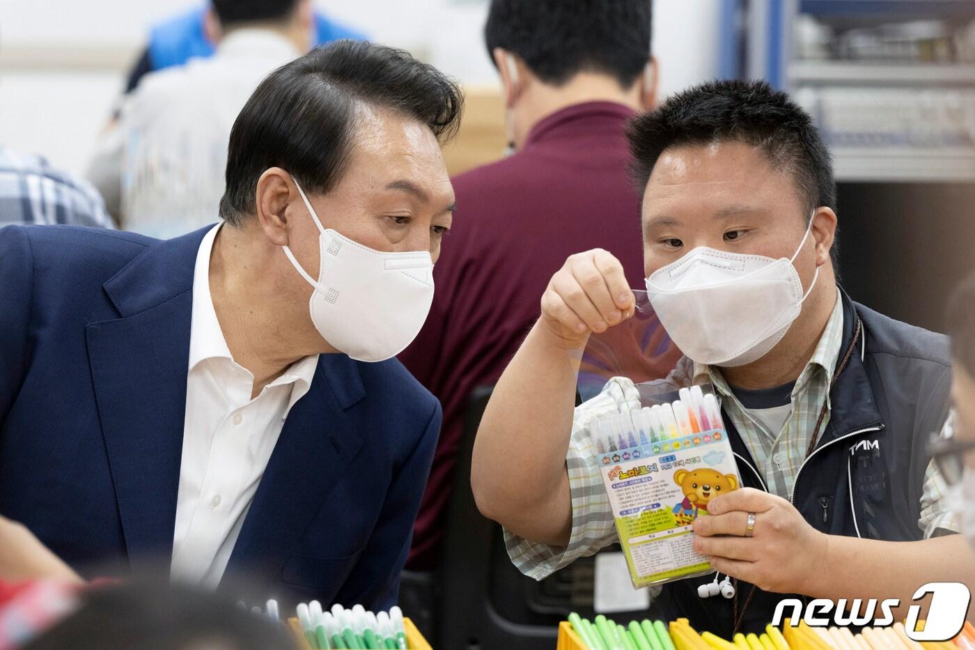 본문 이미지 - 윤석열 대통령이 18일 오후 서울 강남구 충현복지관 보호작업장에서 발달장애인 훈련생 및 근로인들과 색연필 포장 작업을 체험하고 있다. (대통령실 제공) 2022.8.18/뉴스1 ⓒ News1 오대일 기자