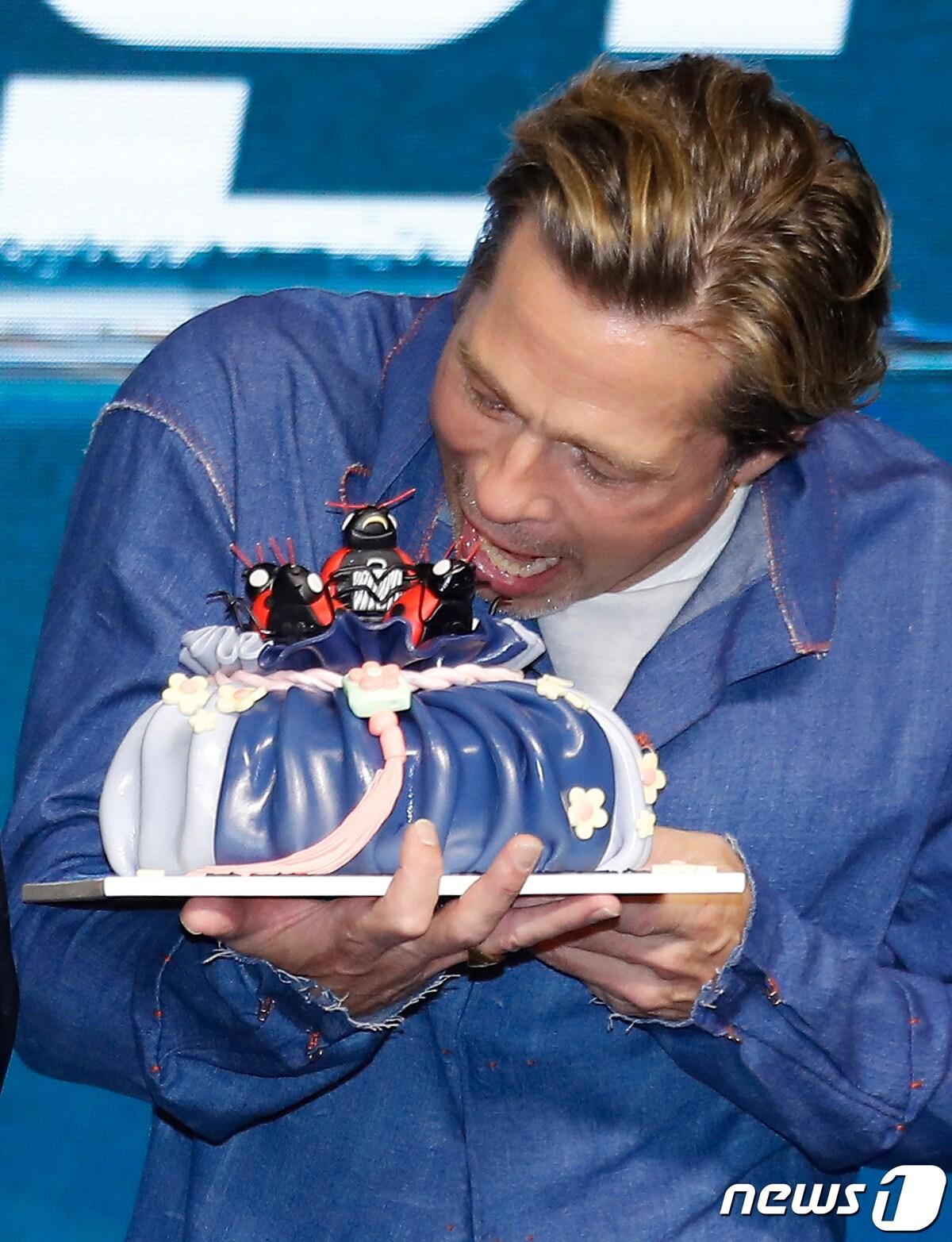 본문 이미지 - 할리우드 배우 브래드 피트가 19일 오전 서울 영등포구 여의도 콘래드 호텔에서 열린 ‘불릿 트레인’(연출 데이빗 레이치) 내한 프레스 컨퍼런스에서 복주머니 케이크를 선물 받고 유쾌한 포즈를 취하고 있다. '불릿 트레인'은 미션수행을 위해 탈출이 불가능한 초고속 열차에 탑승한 언럭키 가이 '레이디버그'(브래드 피트 분)와 고스펙 킬러들의 피 튀기는 전쟁을 담은 논스톱 액션 블록버스터다. 2022.8.19/뉴스1 ⓒ News1 권현진 기자