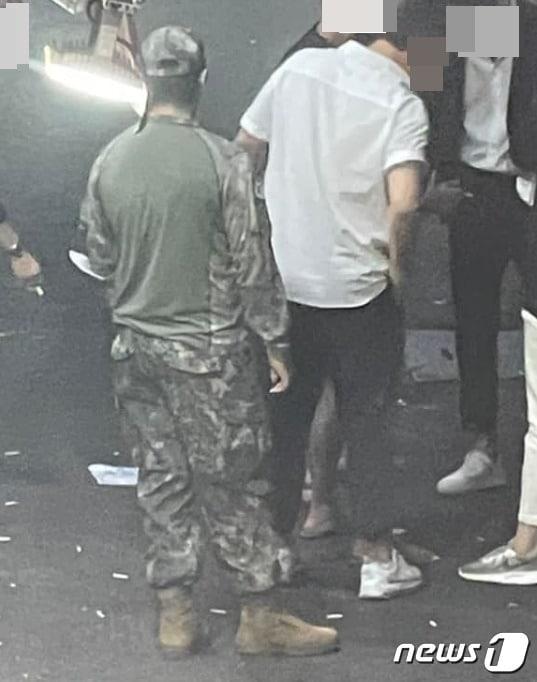 본문 이미지 - 수원역 부근 맥주집 골목에서  컴뱃셔츠 차림으로 담배를 피우고 있는 병사. 컴뱃셔츠는 '작전 및 훈련'때만 착용할 수 있는 특수군복이기에 원칙적으로 외출 때 입고 나올 수 없다. (육대전 갈무리) ⓒ 뉴스1