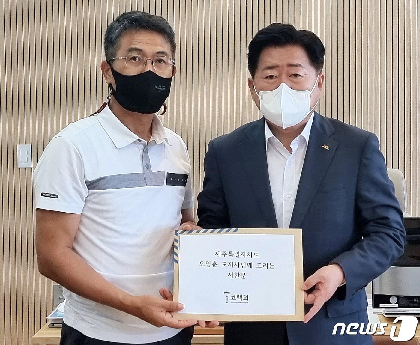 본문 이미지 - 코로나19 백신 피해자 가족 협의회 제주지부 소속 이남훈씨가 3일 제주도청에서 오영훈 제주도지사에게 코로나19 백신 부작용 피해에 대한 공식 사과와 대책 마련을 촉구하는 내용의 서한을 전달하고 있다.&#40;코로나19 백신 피해자 가족 협의회 제주지부 제공&#41;ⓒ 뉴스1