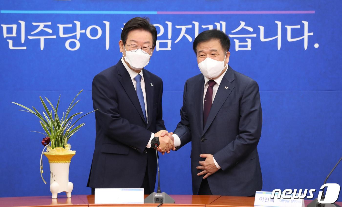 본문 이미지 - 이재명 더불어민주당 대표가 30일 오전 서울 여의도 국회에서 이진복 대통령실 정무수석으로부터 윤석열 대통령의 축하난을 전달받은 후 악수하고 있다. (공동취재) 2022.8.30/뉴스1 ⓒ News1 이재명 기자
