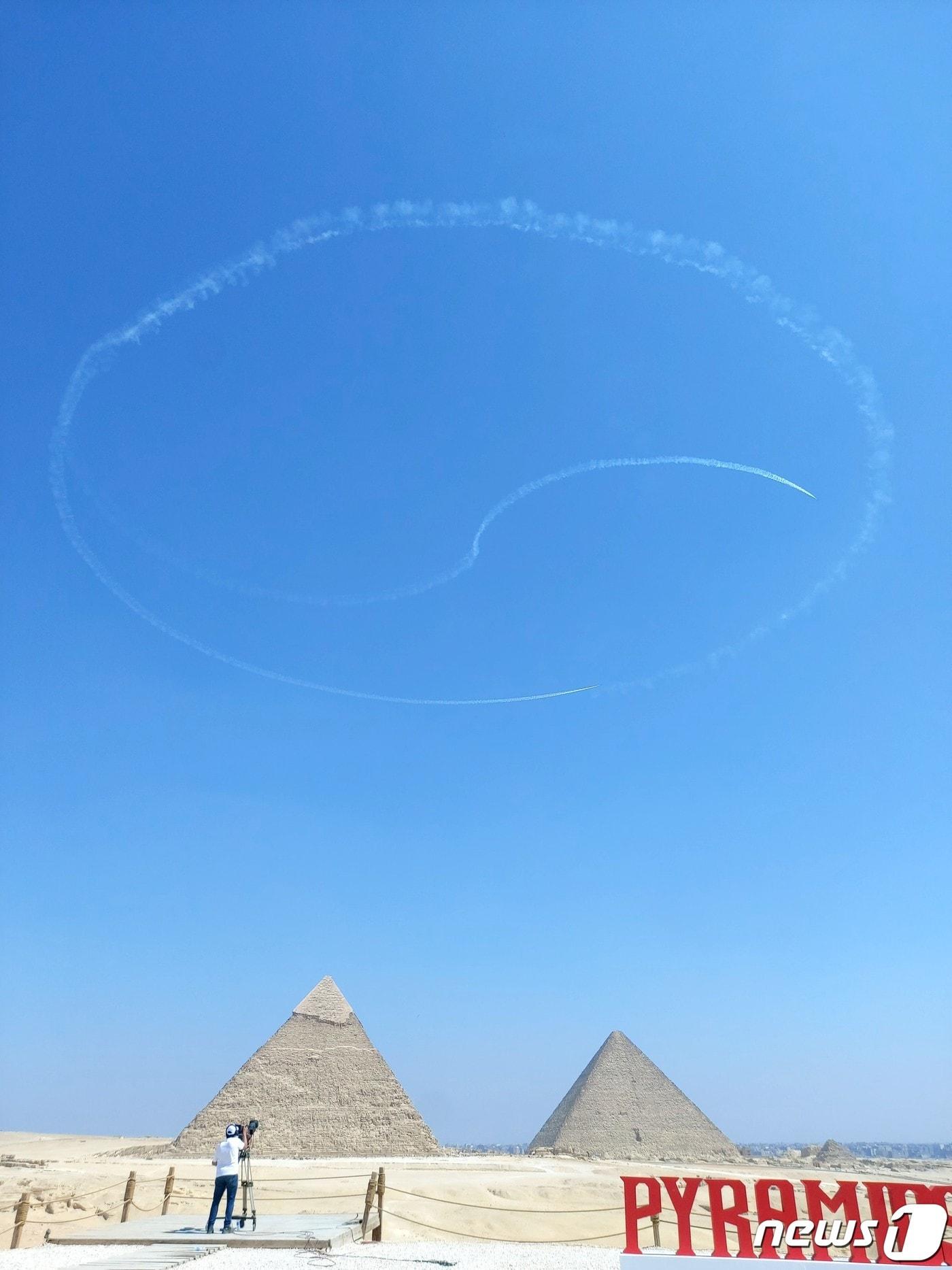 본문 이미지 - 공군 특수비행팀 블랙이글스가 3일(현지시간) 이집트 카이로 인근 기지 피라미드 일대에서 진행된 피라미드 에어쇼 2022에서 태극문양을 그리고 있다. (국방부 공동취재단) 2022.8.4/뉴스1