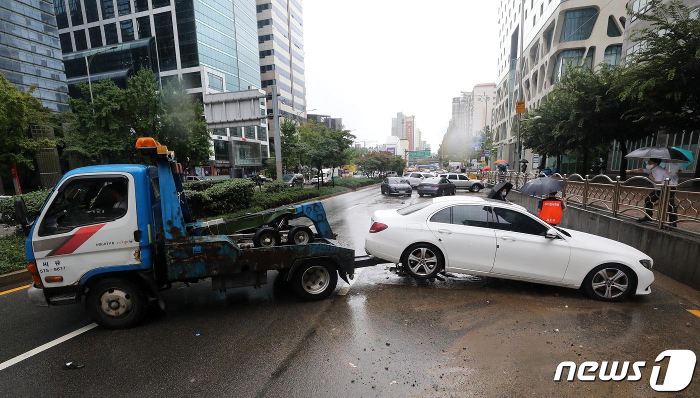 본문 이미지 - 서울을 비롯한 중부지역에 기록적인 폭우가 내린 뒤인 지난해 8월9일 서울 서초구 서초동 진흥아파트 앞 서초대로에 폭우에 침수, 고립된 차량이 견인되고 있다. 2022.8.9/뉴스1 ⓒ News1 박세연 기자