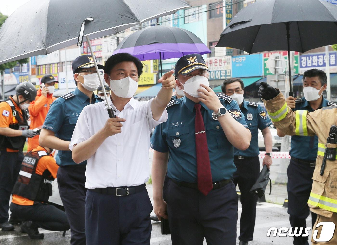 본문 이미지 - 조용익 부천시장이 침수피해가 발생한 약대오거리에서 원미경찰서장과 대화를 나누고 있다. / 뉴스1