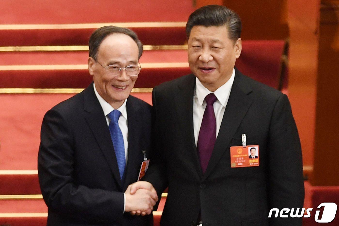 본문 이미지 - 왕치산(왼쪽) 전 중국 공산당 중앙기율검사위원회(CCDI)과 시진핑(오른쪽) 국가주석이 악수를 하고 있다. 2018.03.17 ⓒ AFP=뉴스1 ⓒ News1 정윤미 기자
