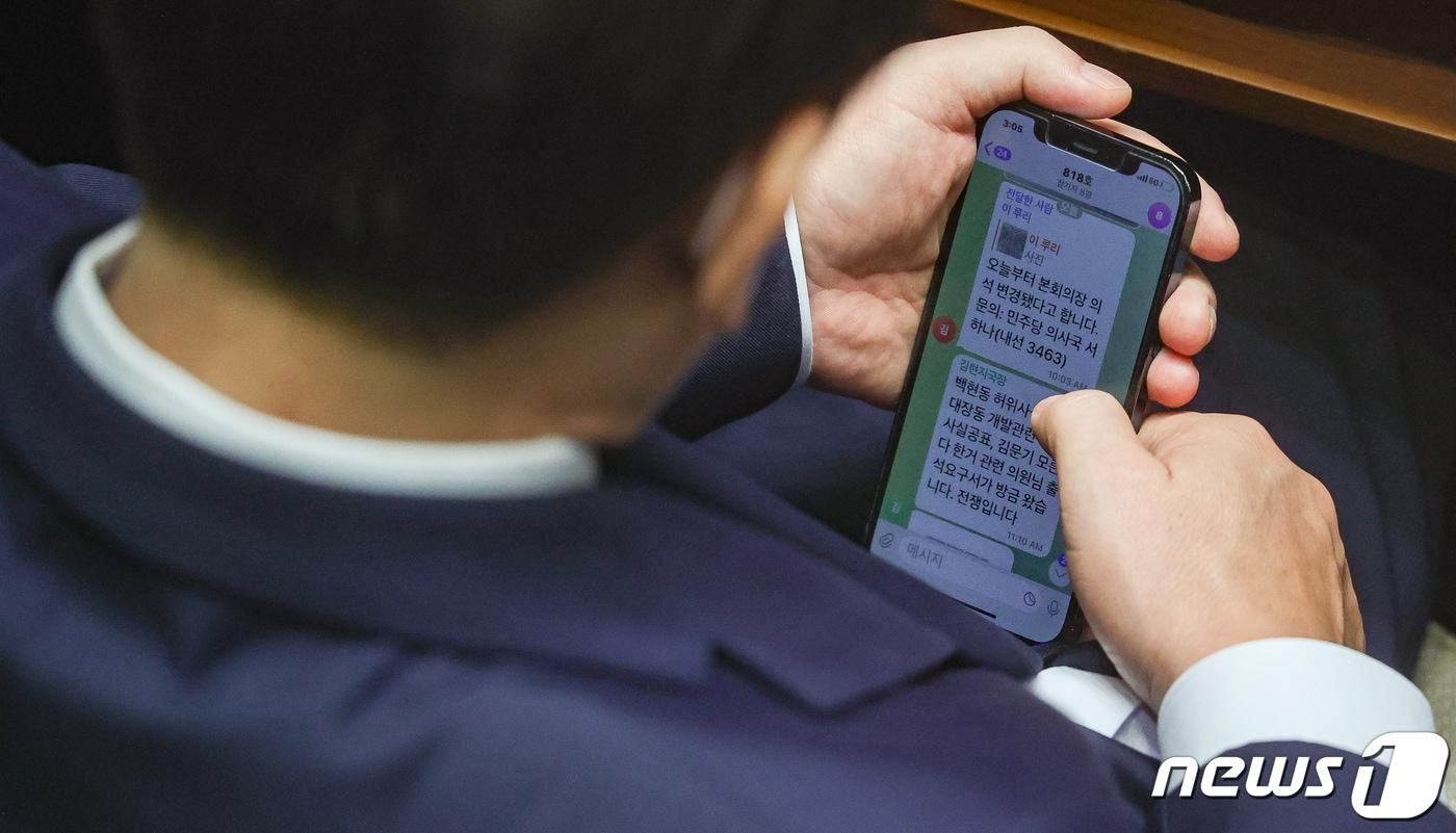 이재명 더불어민주당 대표가 2022년 9월 1일 서울 여의도 국회에서 열린 본회의에서 김현지 보좌관&#40;전 경기도청 비서관&#41;에게 &#34;백현동 허위사실공표, 대장동 개발관련 허위사실공표, 김문기&#40;대장동 의혹 관련으로 수사를 받다가 성남도시개발공사 개발1처장&#41; 모른다 한거 관련 의원님 출석요구서가 방금 왔습니다. 전쟁입니다＂라는 문자를 받고 있다. &#40;공동취재&#41; 2022.9.1/뉴스1 ⓒ News1 유승관 기자