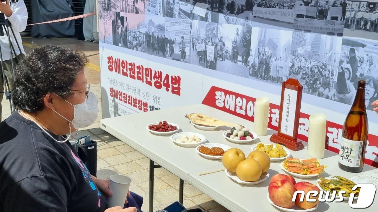 본문 이미지 - 전국장애인차별철폐연대(전장연) 회원이 10일 서울 영등포구 여의도동 이룸센터  앞에서 추석 차례상을 지내고 장애인권리예상 보장을 촉구했다.  ⓒ 전장연 제공