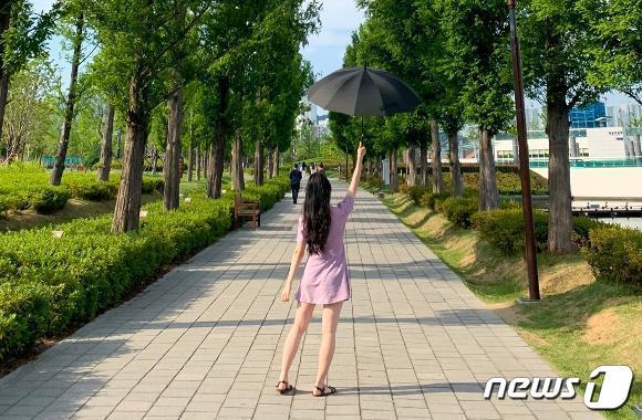 본문 이미지 - BTS 멤버 뷔가 다녀간 부산시민공원에서 한 방문객이 뷔와 똑같은 포즈로 기념사진을 찍고 있다.(비짓부산 갈무리)