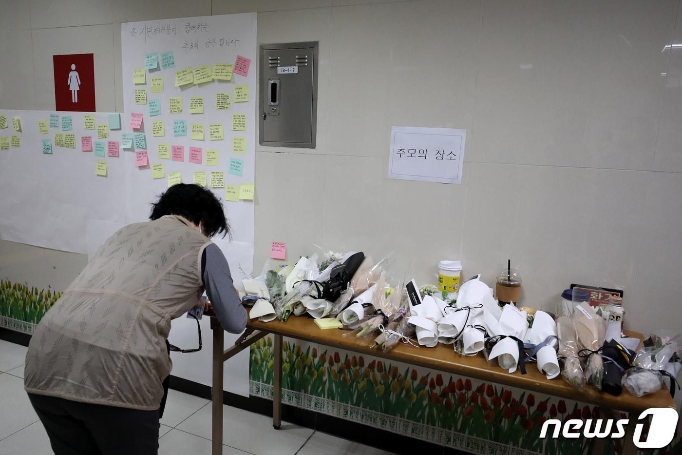 본문 이미지 - 16일 오전 역무원 스토킹 살인사건이 발생한 서울지하철 2호선 신당역 화장실 앞에 마련된 추모공간을 찾은 시민이 추모문구를 적고 있다.2022.9.16/뉴스1 ⓒ News1 이광호 기자