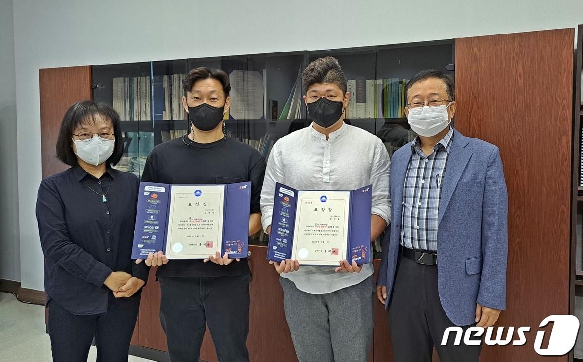 본문 이미지 - 김해문화재단이 수영장에서 의식을 잃은 시민을 구한 조재민 과장(왼쪽 두번째)과 최진호 대리(왼쪽 세번째)에게 표창장을 수여하고 있다. (김해문화재단 제공)