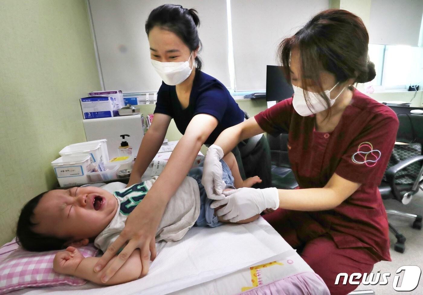 본문 이미지 - 21일 오전 대전의 한 병원에서 생후 10개월된 영아가 독감백신을 맞고 울음을 터뜨리고 있다.