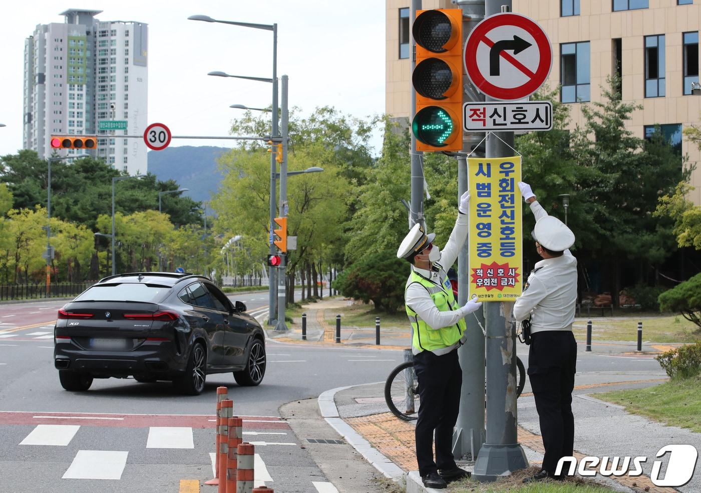 유성경찰서 교통안전계 소속 경찰관들이 22일 대전 유성구 원신흥네거리에서 '우회전 신호등' 시범운영 계도 및 지도를 하고 있다.  2022.9.22/뉴스1 ⓒ News1 김기태 기자
