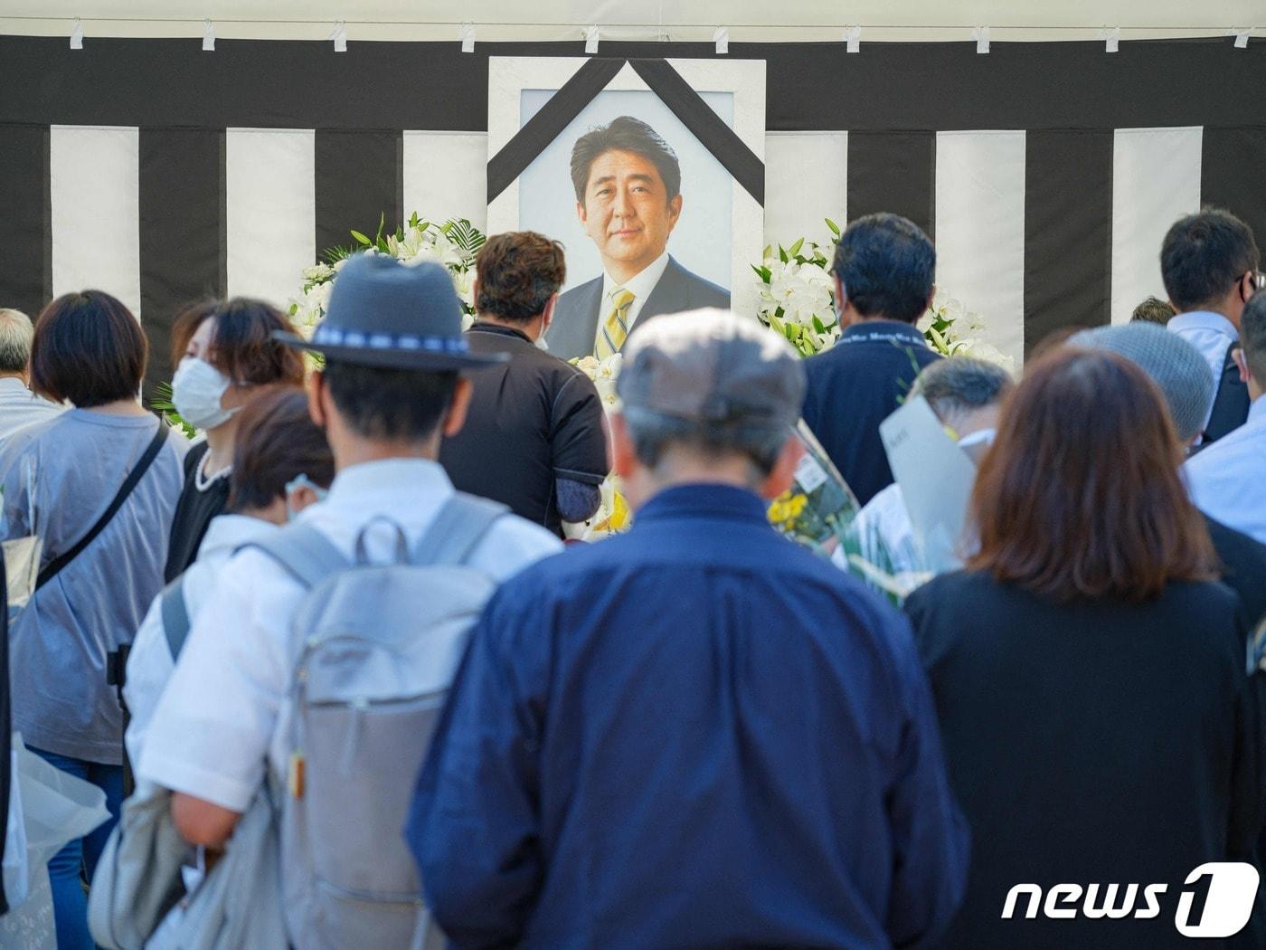 본문 이미지 - 27일 (현지시간) 아베 신조 전 일본 총리의 국장에 앞서 도쿄 니혼부도칸에서 시민들이 조문을 하고 있다.  2022.09.27 ⓒ AFP=뉴스1