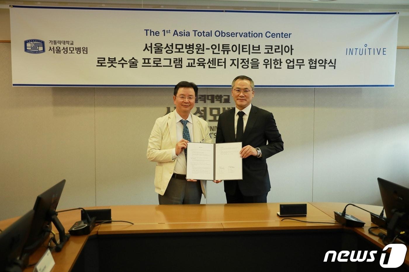 본문 이미지 - 윤승규 서울성모병원 병원장과 인튜이티브 최용범 한국지사대표가 아시아 최초로 '로봇수술 프로그램 교육센터(Total Observation Center)' 지정을 위한 업무협약을 체결한 후 기념사진을 촬영했다. (서울성모병원 제공)