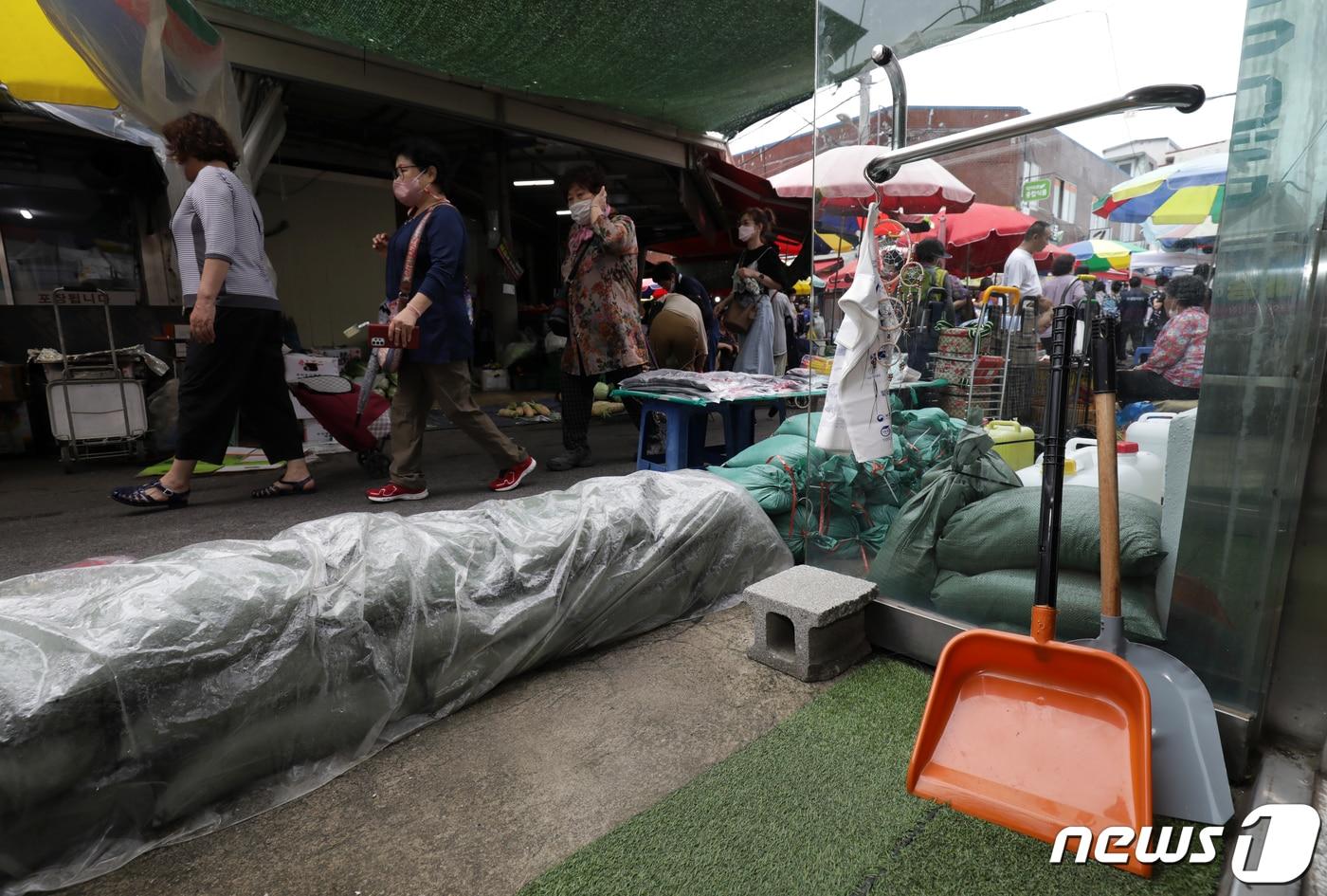 본문 이미지 - 울산 중구 태화종합시장에서 상인이 모래주머니를 준비해 침수에 대비하고 있다.  ⓒ News1 윤일지 기자