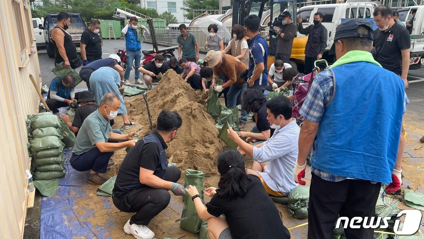 본문 이미지 - 5일 오후 경남 창원시 마산합포구 구항 배수펌프장에서 구청 직원들과 주민 30여명이 5kg 짜리 포대주머니에 모래를 담고 있다. 2022.9.5/뉴스1 강정태 기자