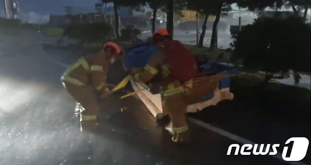 본문 이미지 - 5일 오후 6시53분쯤 제주 서귀포시 대정읍 하모리 도로에 보트가 날아와 안전조치가 이뤄지고 있다.(제주소방안전본부 제공)