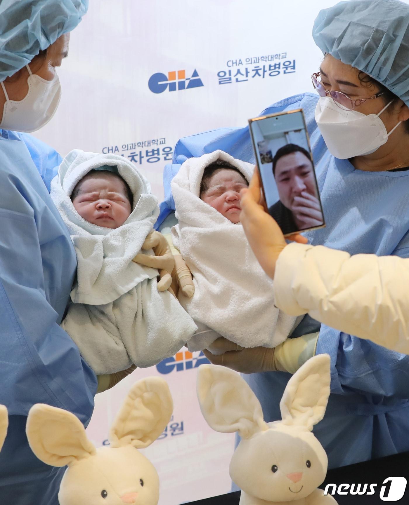 본문 이미지 - 쌍둥이 아이를 화면 너머로 보는 아빠의 모습. ⓒ News1 