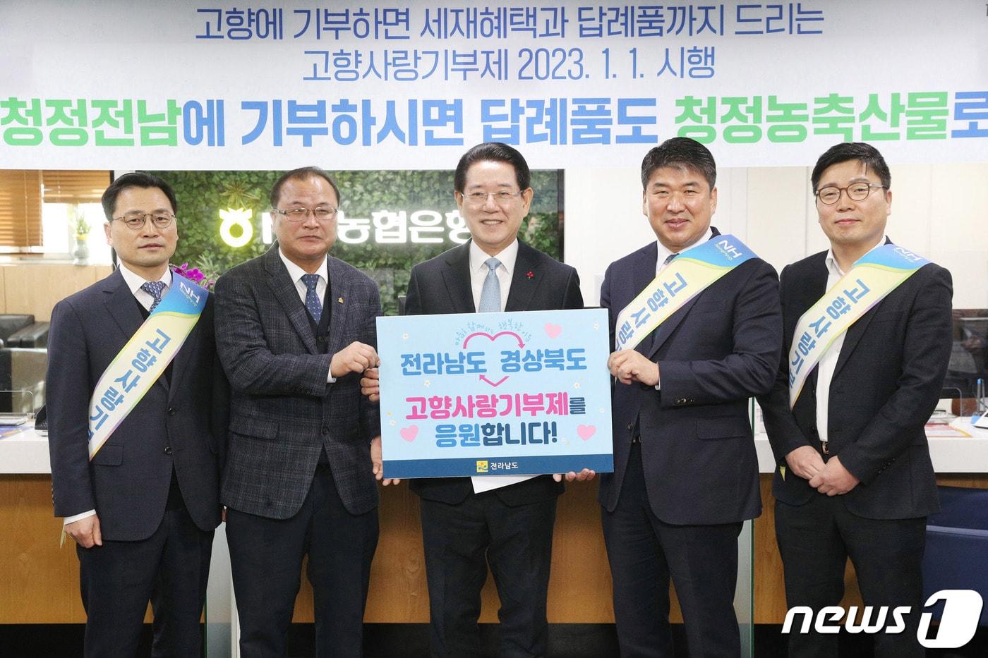 본문 이미지 - 김영록 전라남도지사가 10일 오전 NH농협은행 전남도청점에서 전라남도와 경상북도 양 지역의 고향사랑기부제를 응원하는 피켓을 들고 기념 촬영을 하고 있다. (전남도 제공) 2023.1.10/뉴스1