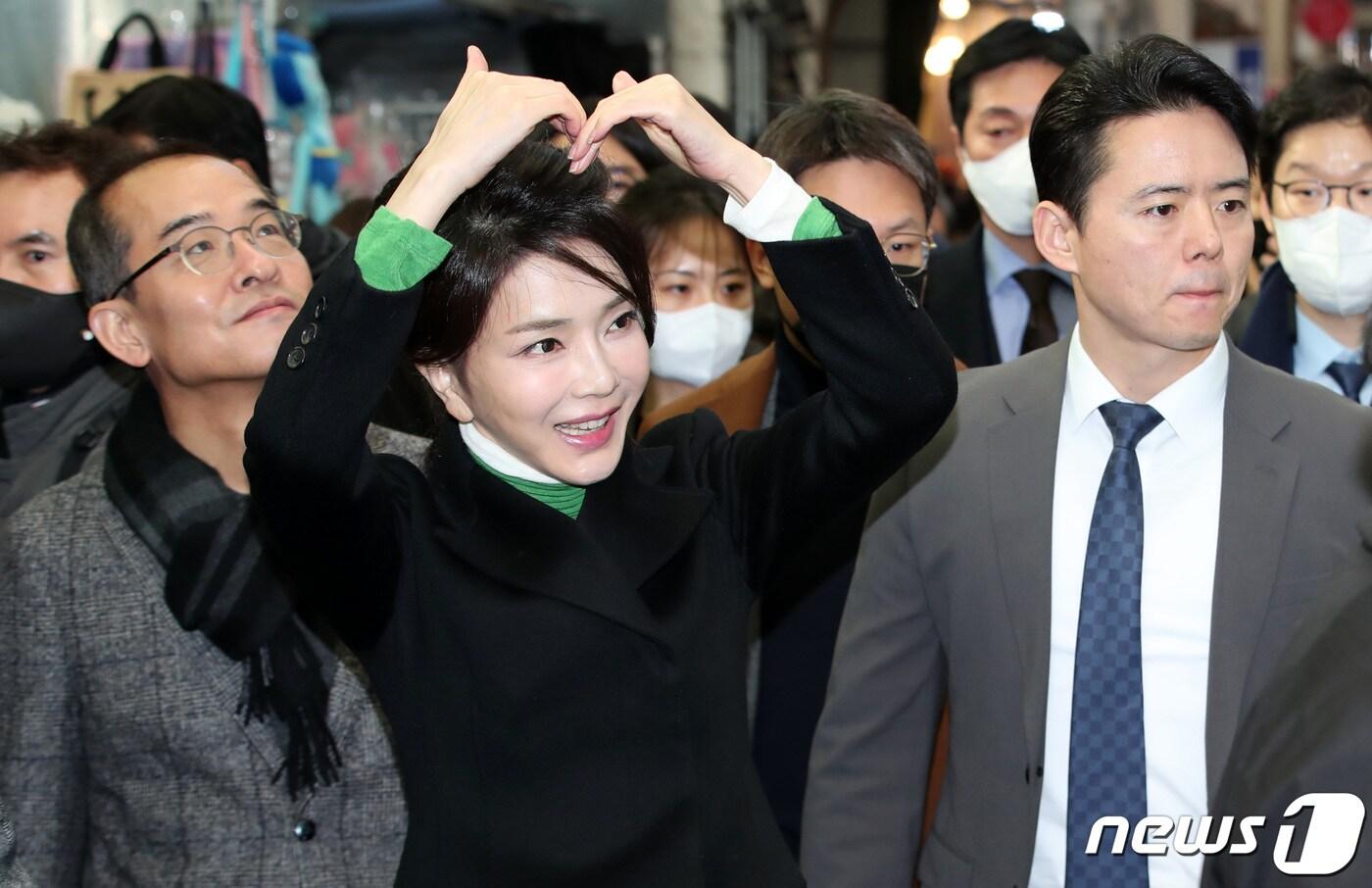 윤석열 대통령의 부인 김건희 여사가 11일 오후 대구 중구 서문시장을 찾아 시민들을 향해 머리 위로 하트를 만들어 보이 인사하고 있다. 2023.1.11/뉴스1 ⓒ News1 공정식 기자