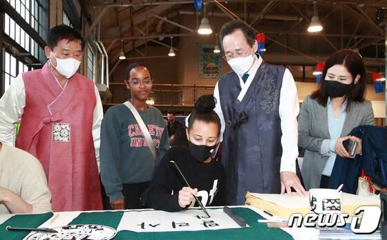 본문 이미지 - 지난 2022년 6월 캐나다를 방문한 당시 송하진 전북지사가 서예 쓰기 체험에 나선 캐나다 소녀를 바라보고 있다.&#40;전북도 제공&#41;2022.6.2/ⓒ 뉴스1