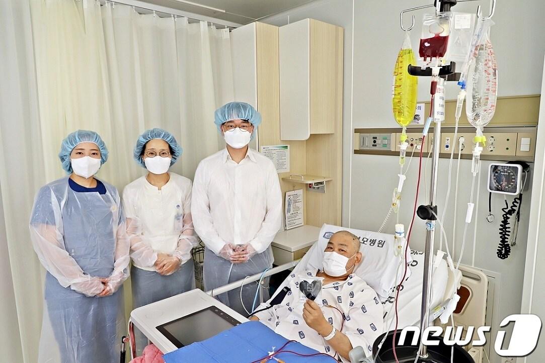 본문 이미지 - (왼쪽부터)김윤희 은평성모병원의 혈액병원 전담간호사, 신영지 혈액병동 매니저, 이준엽 혈액내과 교수가 200번째 조혈모세포이식 환자의 쾌유를 기원하며 기념촬영을 하고 있다.(은평성모병원 제공.)