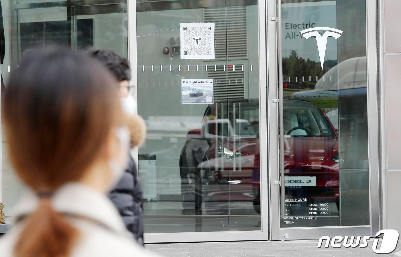 서울시내 한 테슬라 매장 앞으로 시민들이 지나가고 있다. 2023.1.17/뉴스1 ⓒ News1 박세연 기자