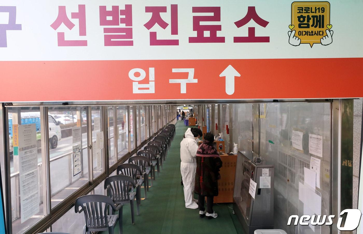 본문 이미지 - 서울 동대문구보건소에 마련된 신종 코로나 바이러스 감염증(코로나19) 선별진료소에서 의료진이 시민에게 검사를 안내하고 있다./뉴스1 ⓒ News1 박세연 기자