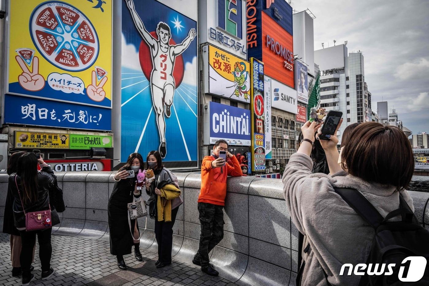 본문 이미지 - 오사카 도톤보리에서 사진 촬영을 하는 관광객들의 모습ⓒ AFP=뉴스1