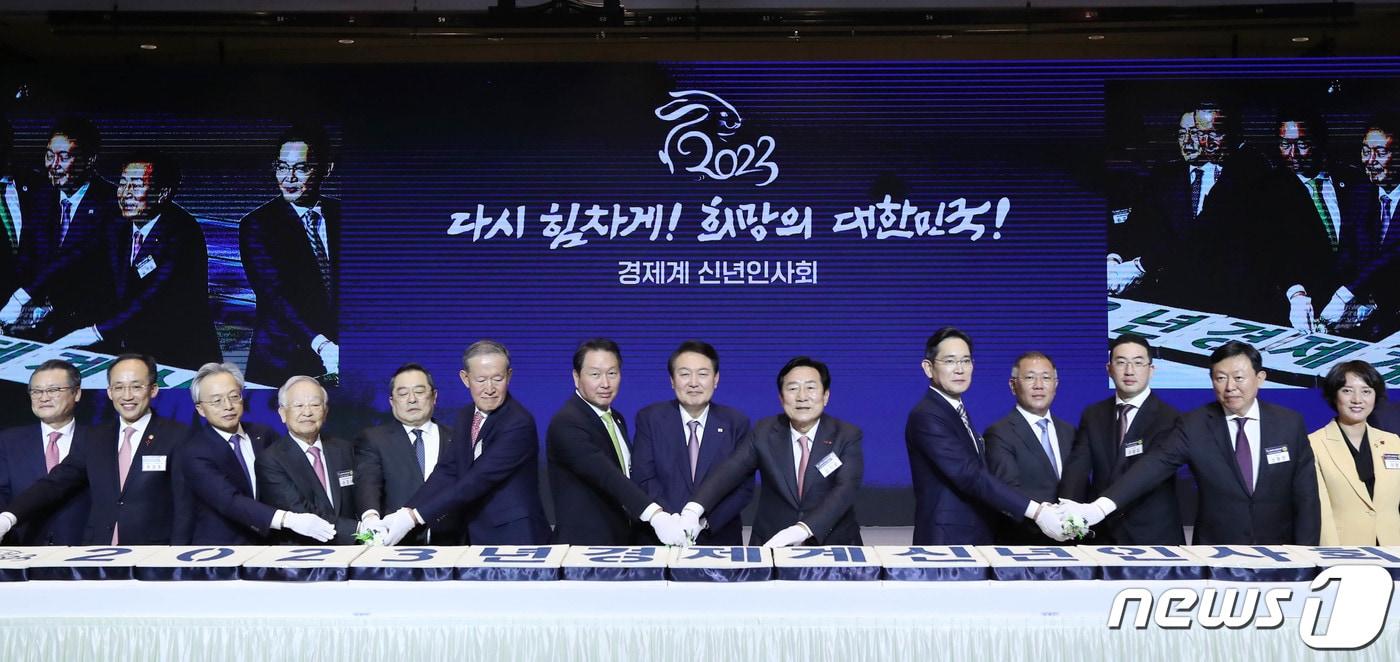 본문 이미지 - 윤석열 대통령과 최태원 대한상의 회장을 비롯한 참석자들이 2일 서울 강남구 코엑스에서 열린 2023년 경제계 신년인사회에서 떡을 자르고 있다. (대한상의 제공) 2023.1.2/뉴스1